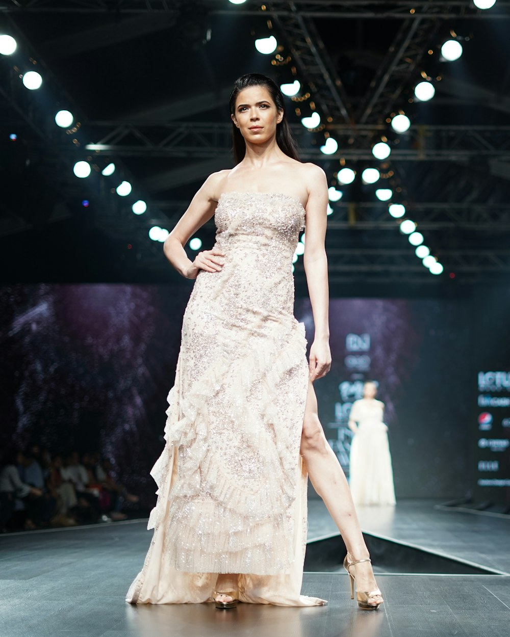 A pale floor-length gown photographed on the runway